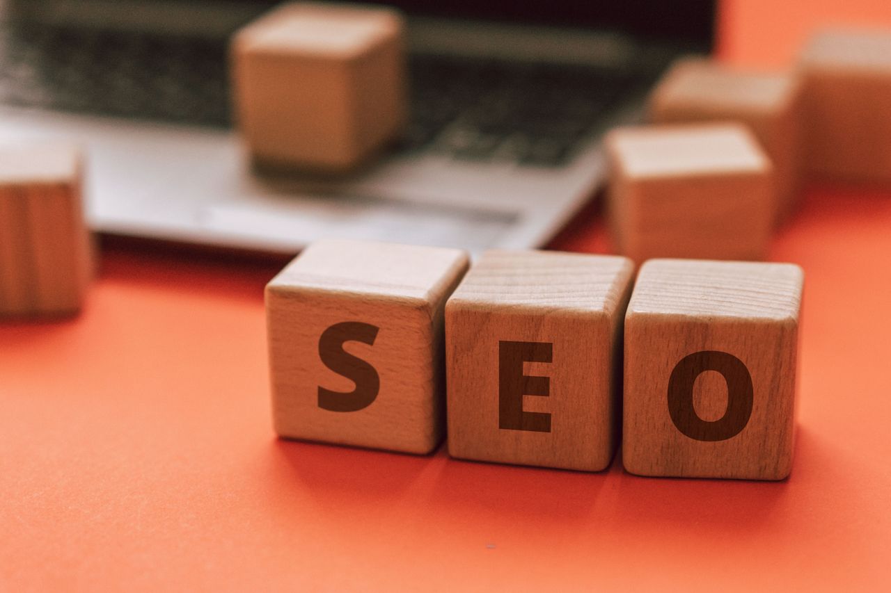 Des blocs en bois formant le mot SEO sur un clavier d’ordinateur illustrent les notions du marketing digital.